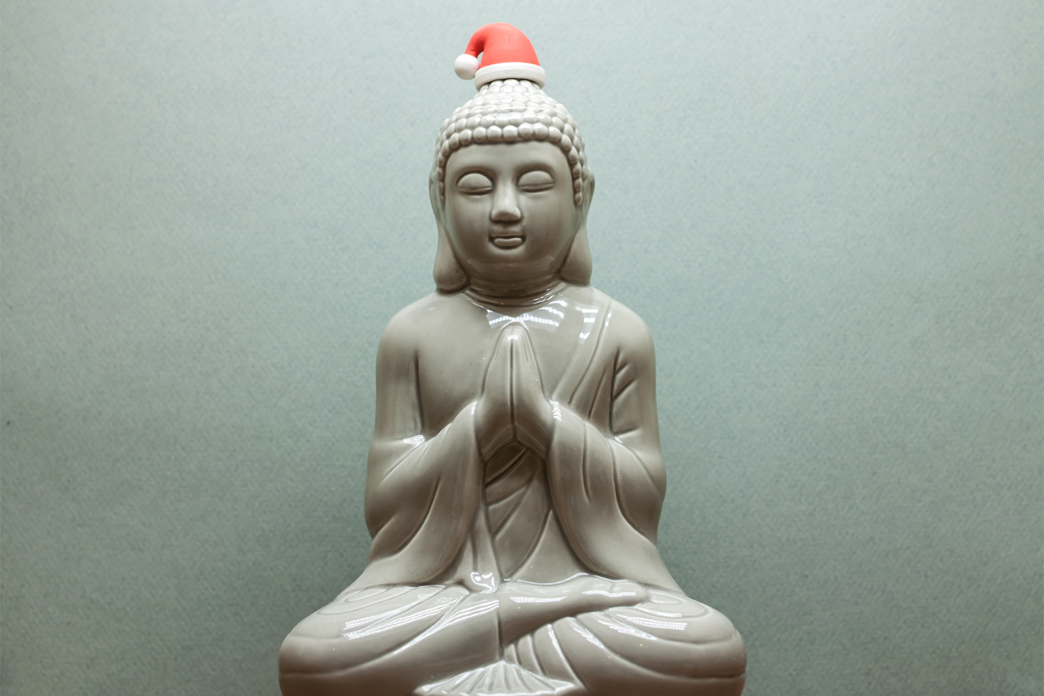 a statue of Siddhartha wearing a Santa hat