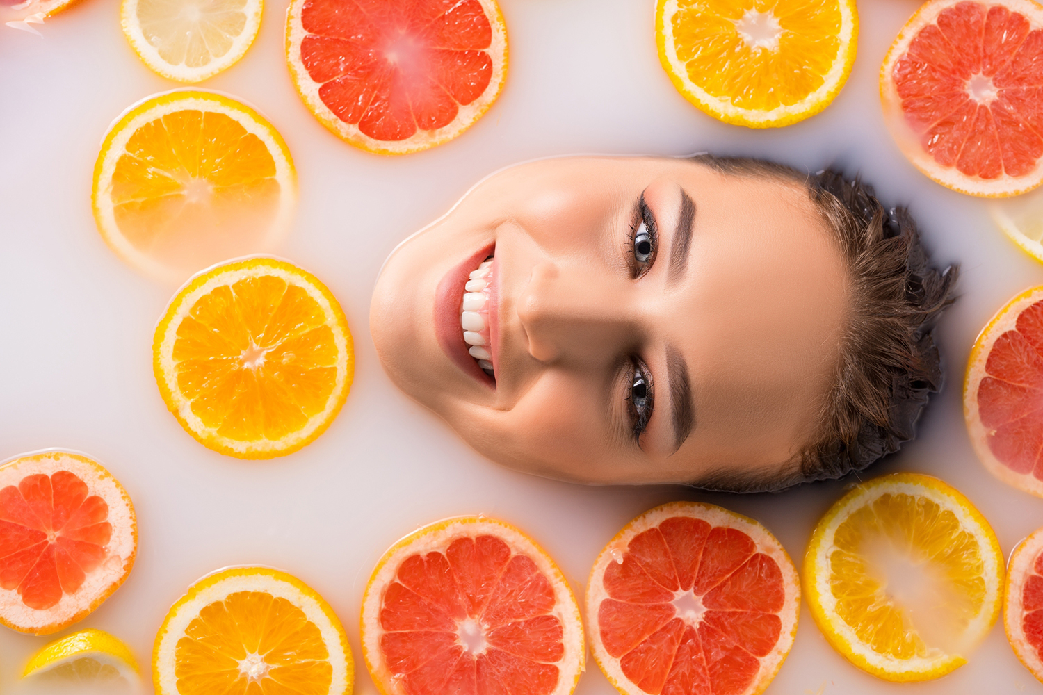 a woman in a bath with soda, salt, and citrus