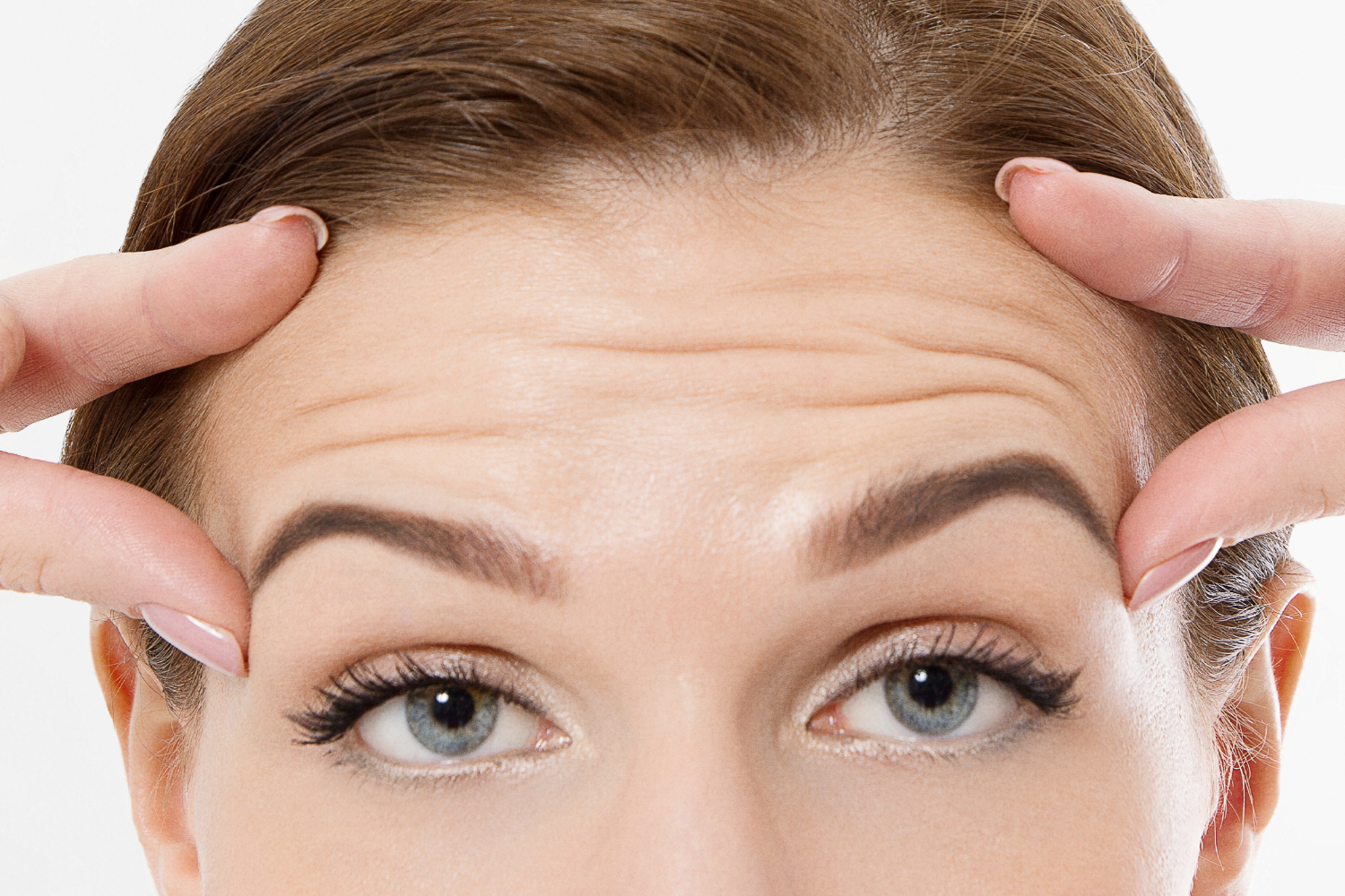 a woman checking the skin on her face for wrinkles