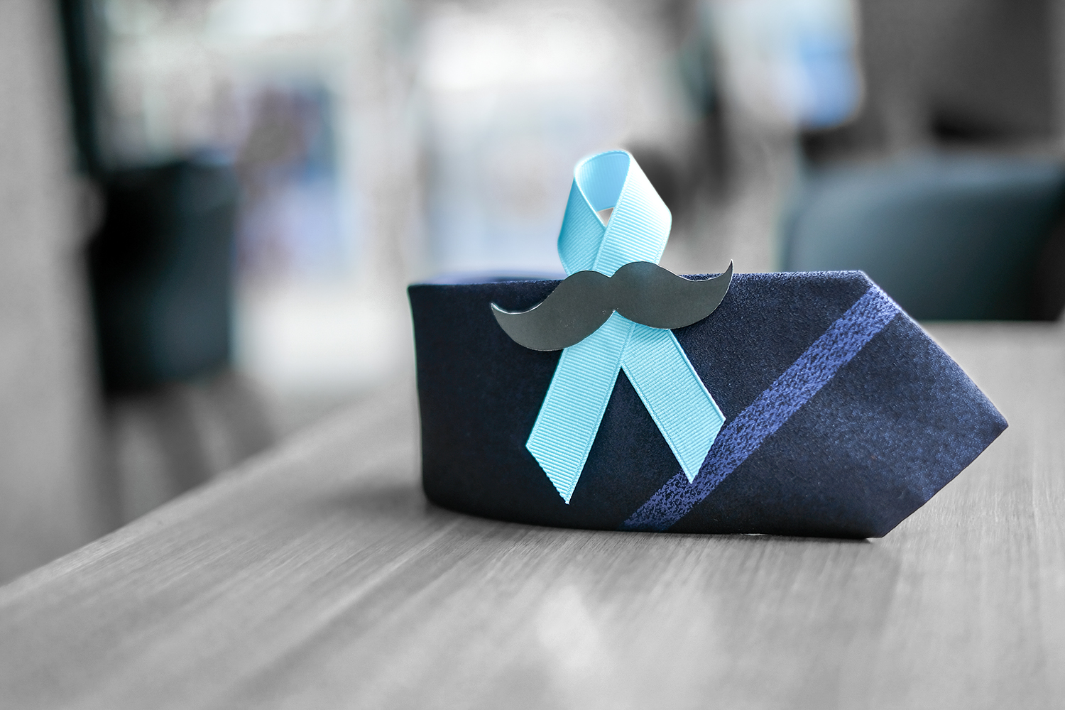 an awareness ribbon on a tie with a fake mustache