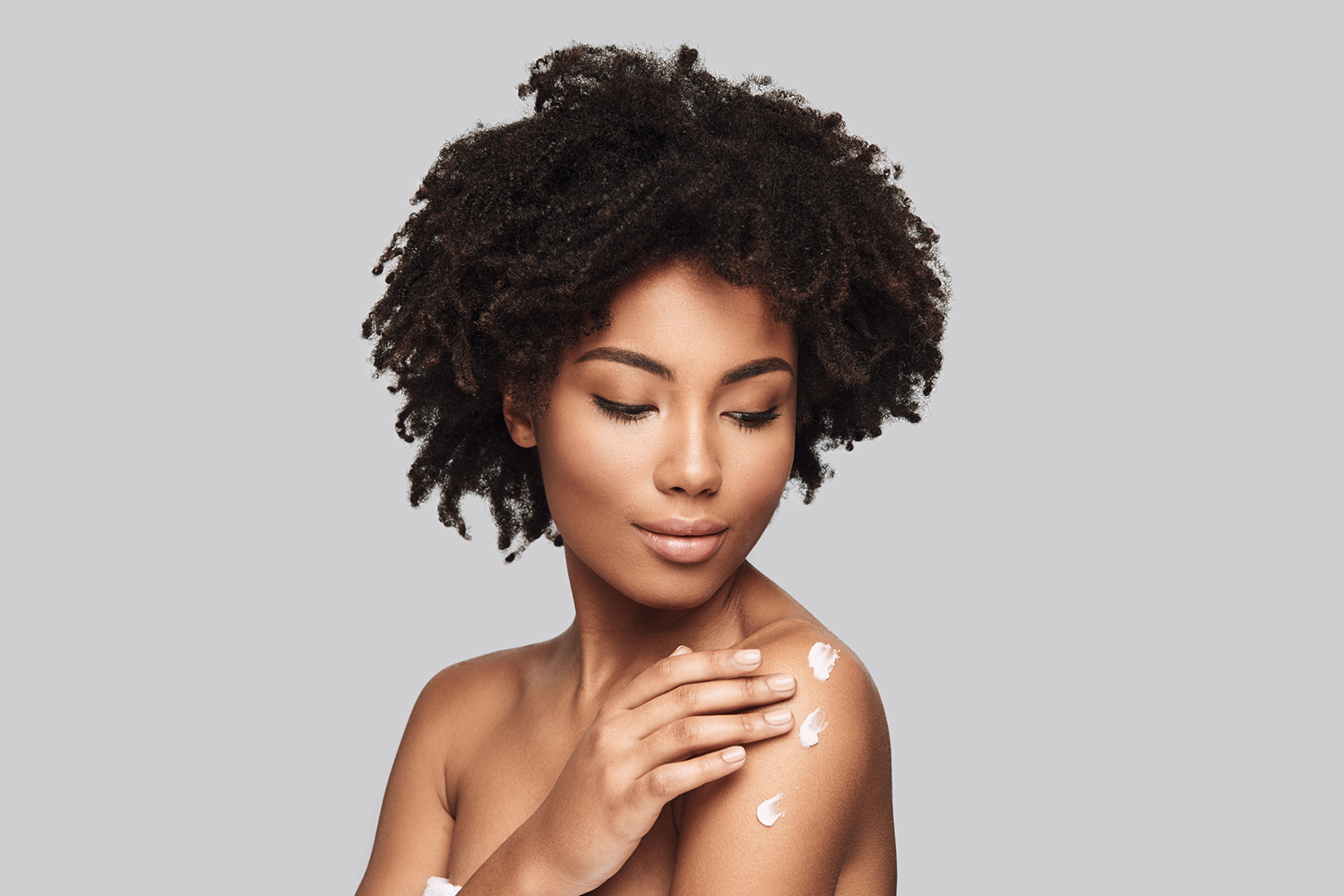 a woman with beautiful skin applying moisturizer