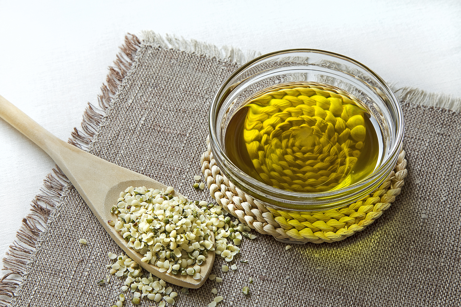 A spoonful of hemp seeds and a bowl of hemp seed oil