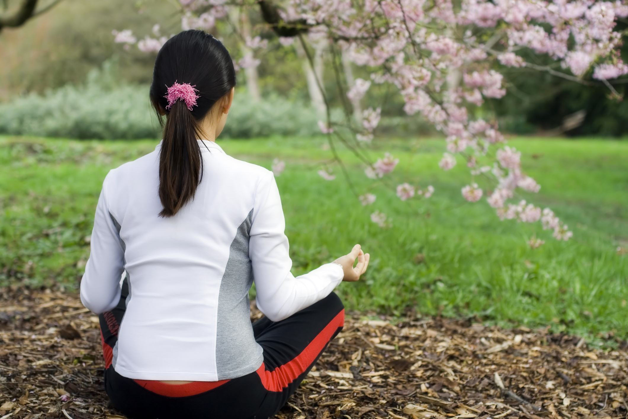 Woman meditating in a park. 