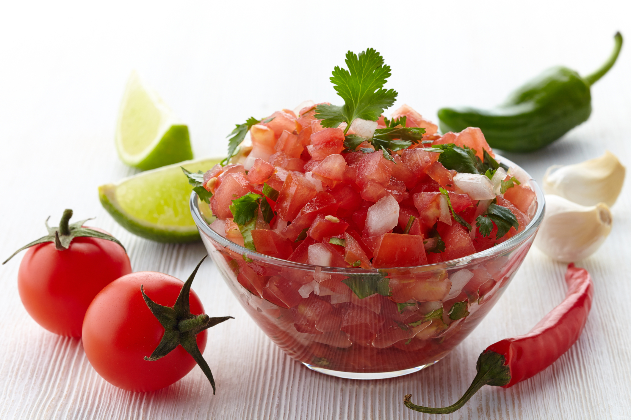 Bowl of salsa surrounded by the ingredients. 
