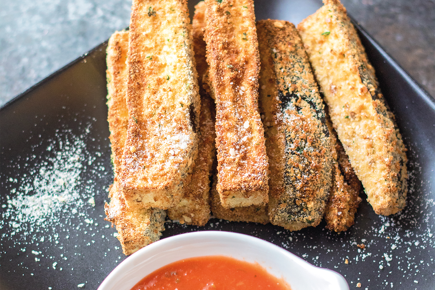 a plate of eggplant fries with marinara for dipping