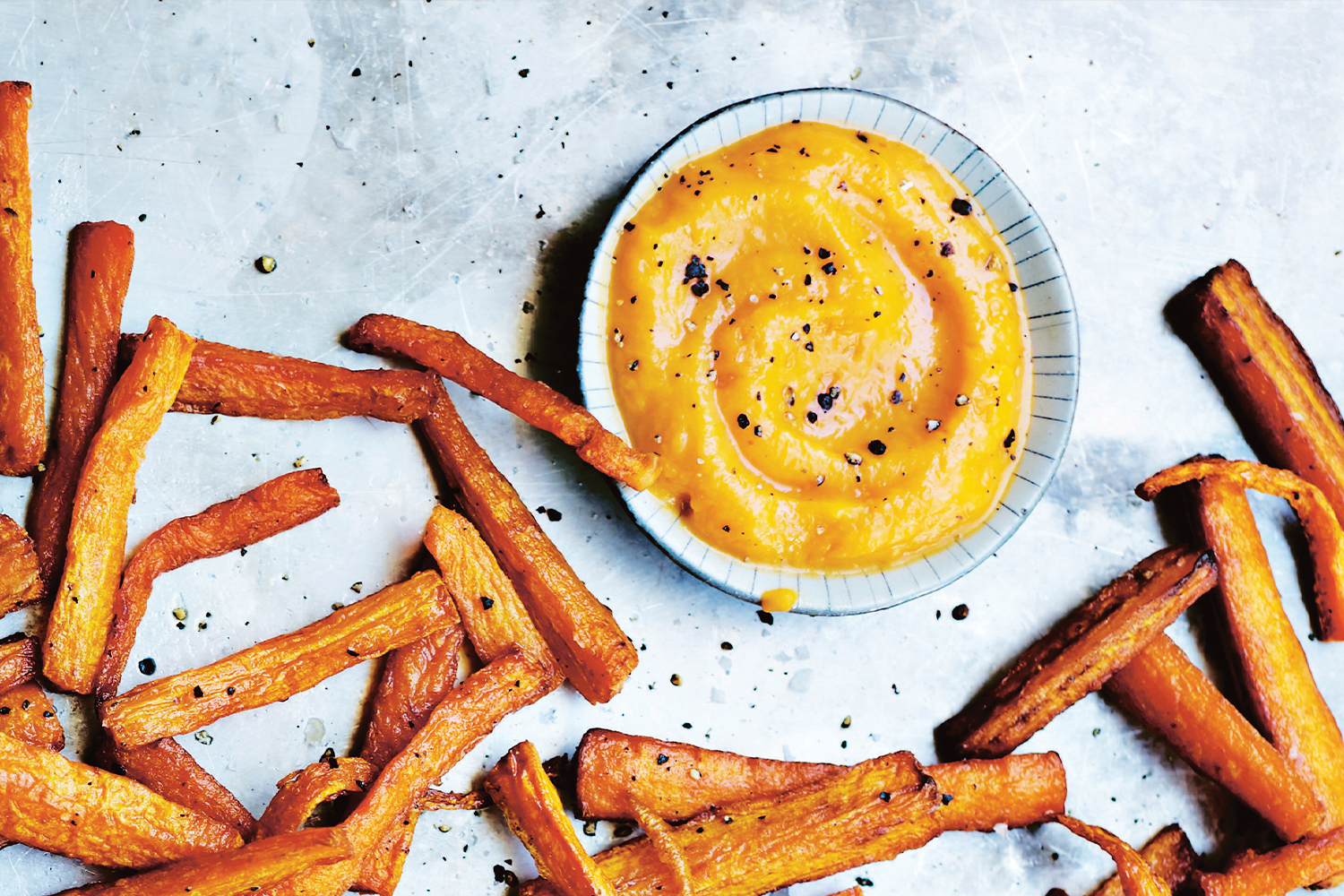 Fiery Butternut Squash Ketchup and Carrot Fries on a metal sheet pan.