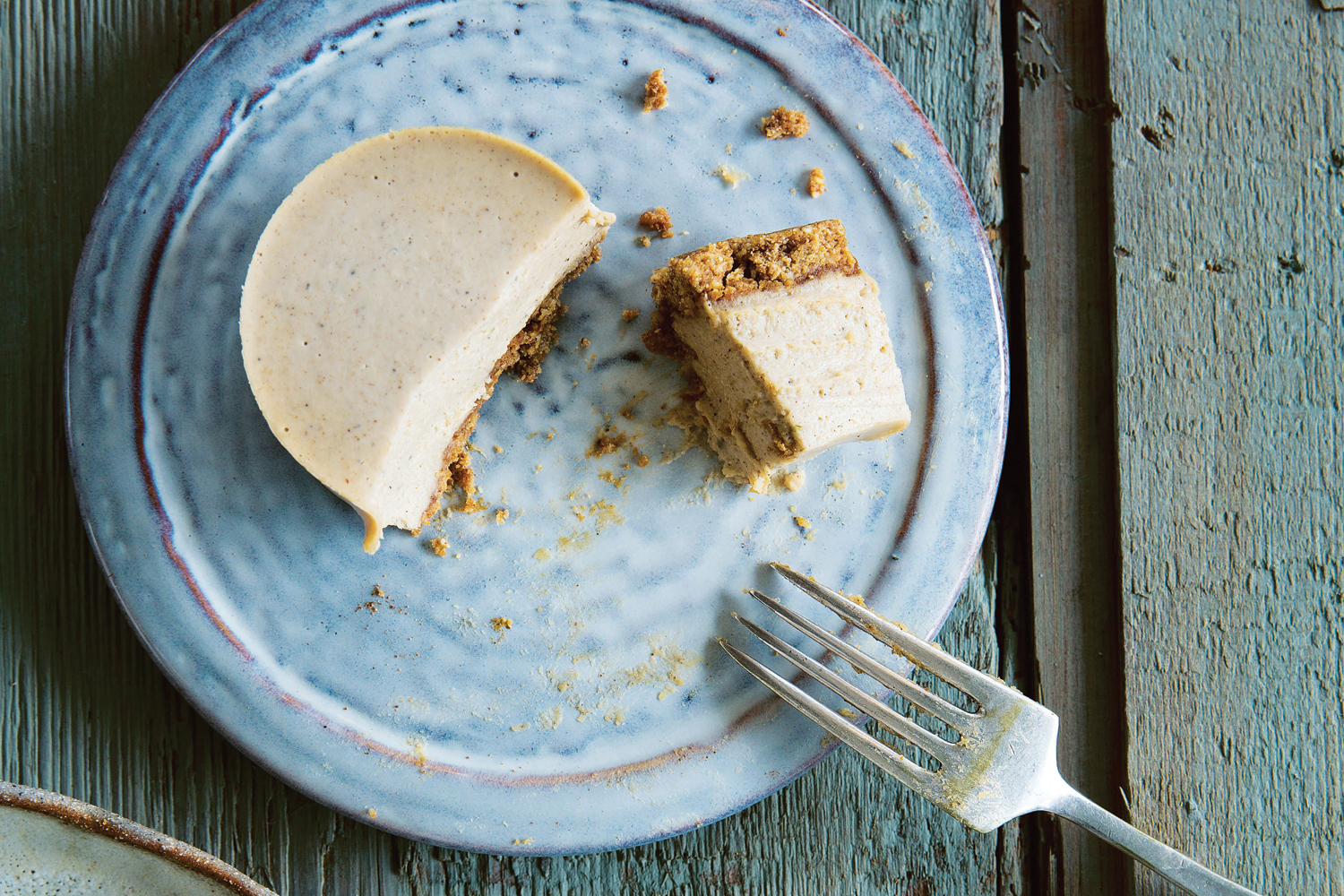 A plated mini-cheesecake with a little taste cut out