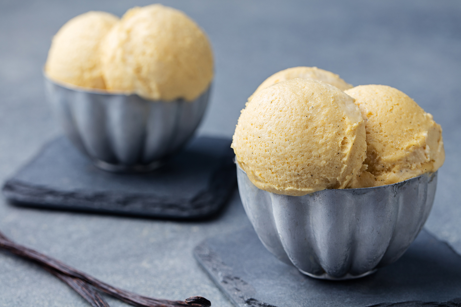 Homemade French Vanilla Ice Cream scooped into two blue bowls.