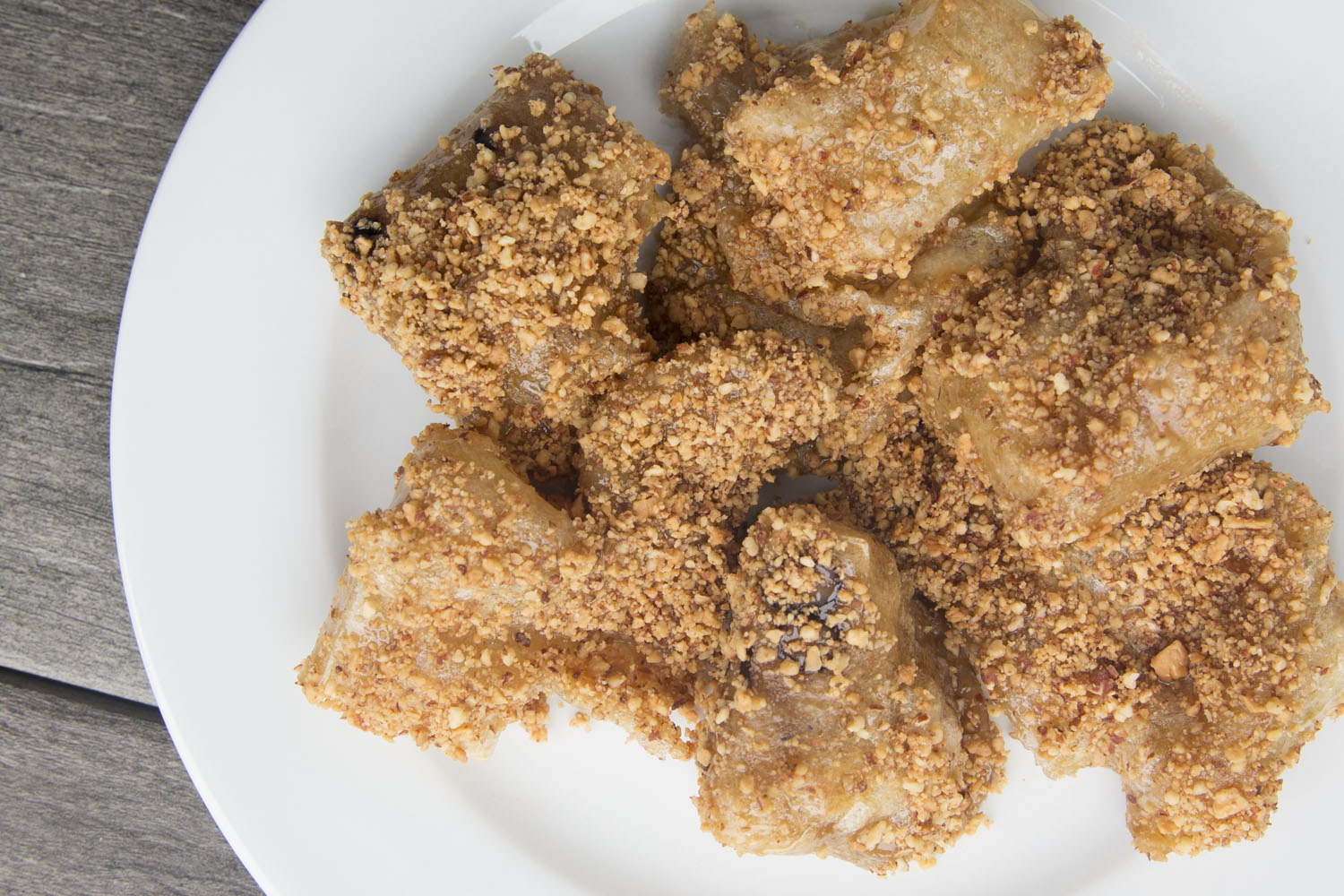 A plate of puffed mochi drizzled in syrup and covered in nuts