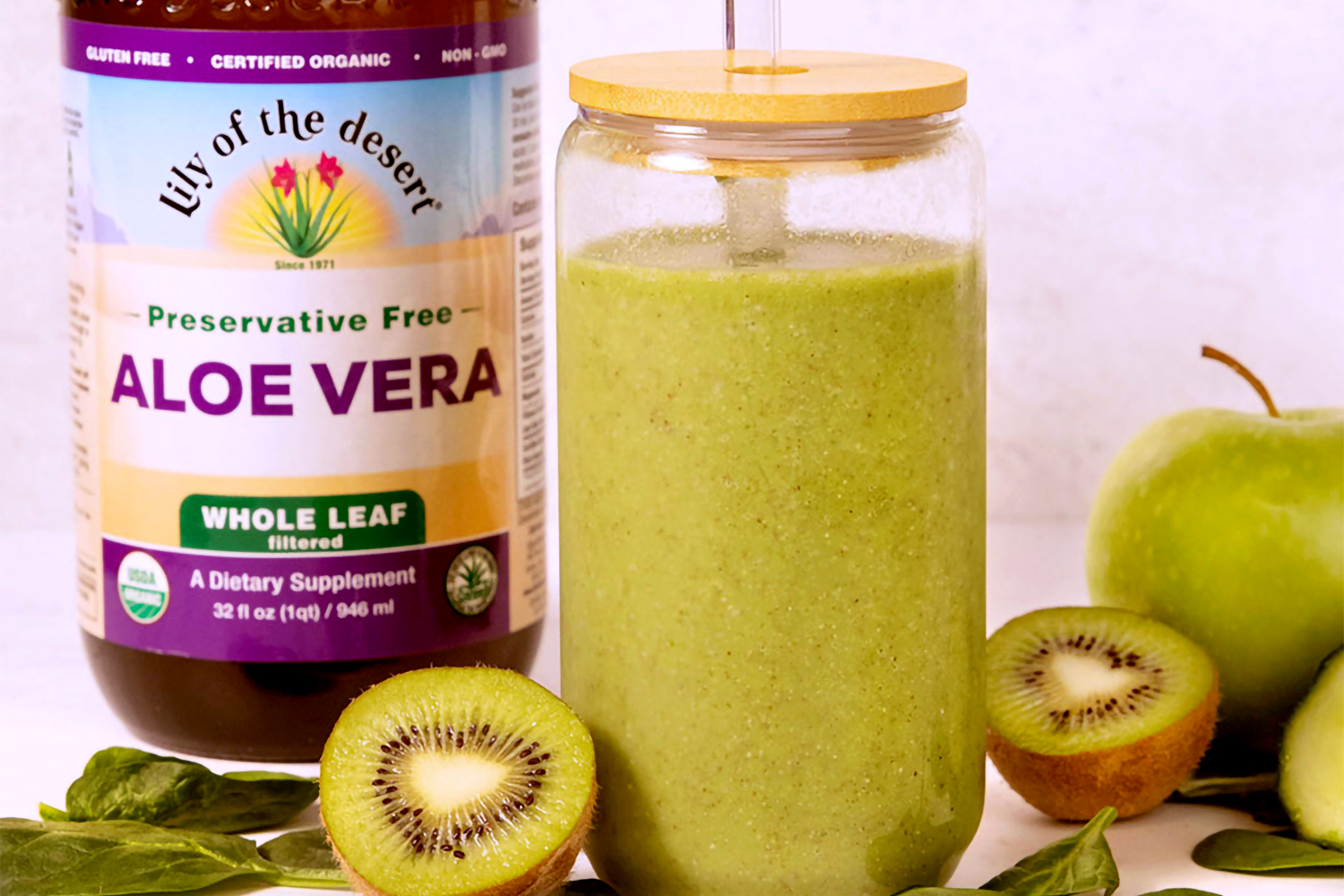 a green smoothie next to a bottle of whole leaf aloe vera