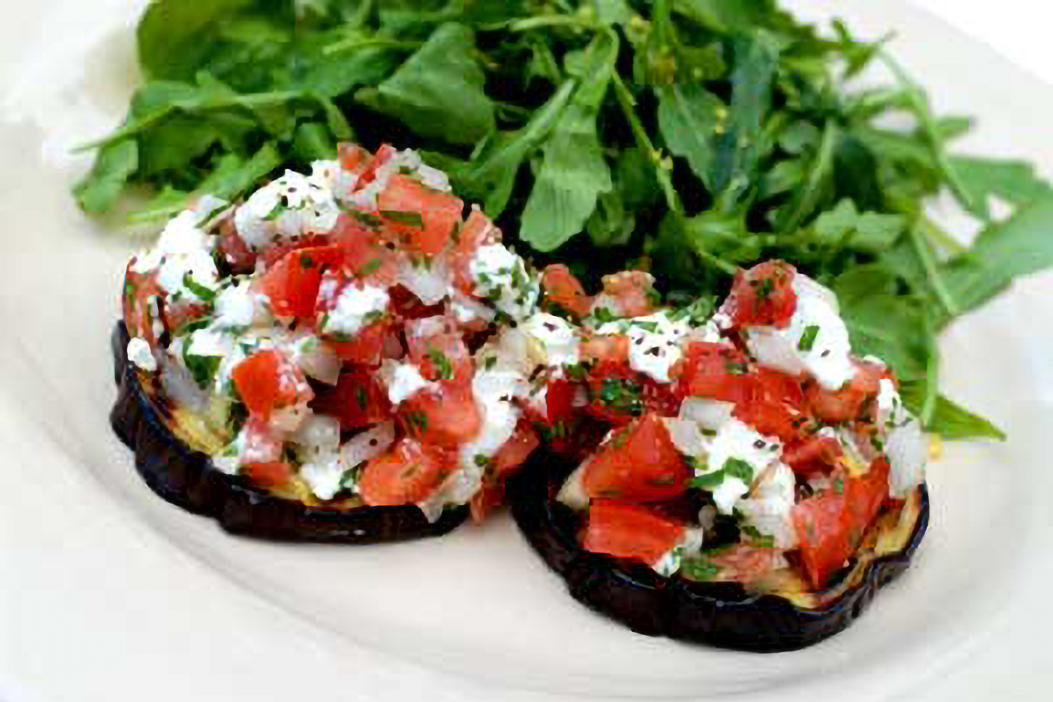 slices of eggplant with tomato and goat cheese on top