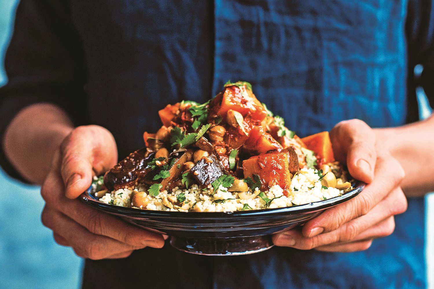 A man holding a heaping plate of Veggie Tagine