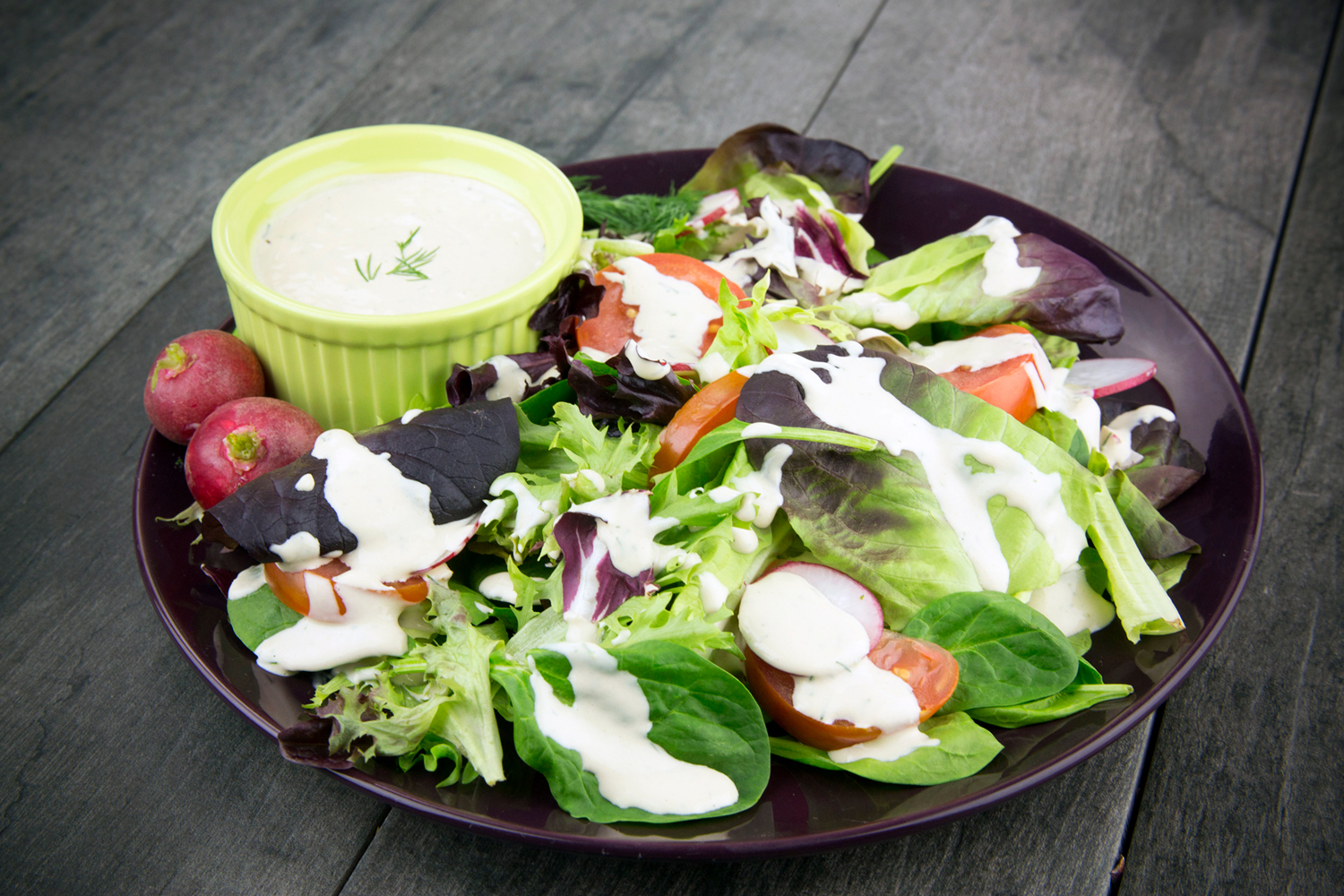 A bowl of salad drizzled with Tahini Dill dressing.