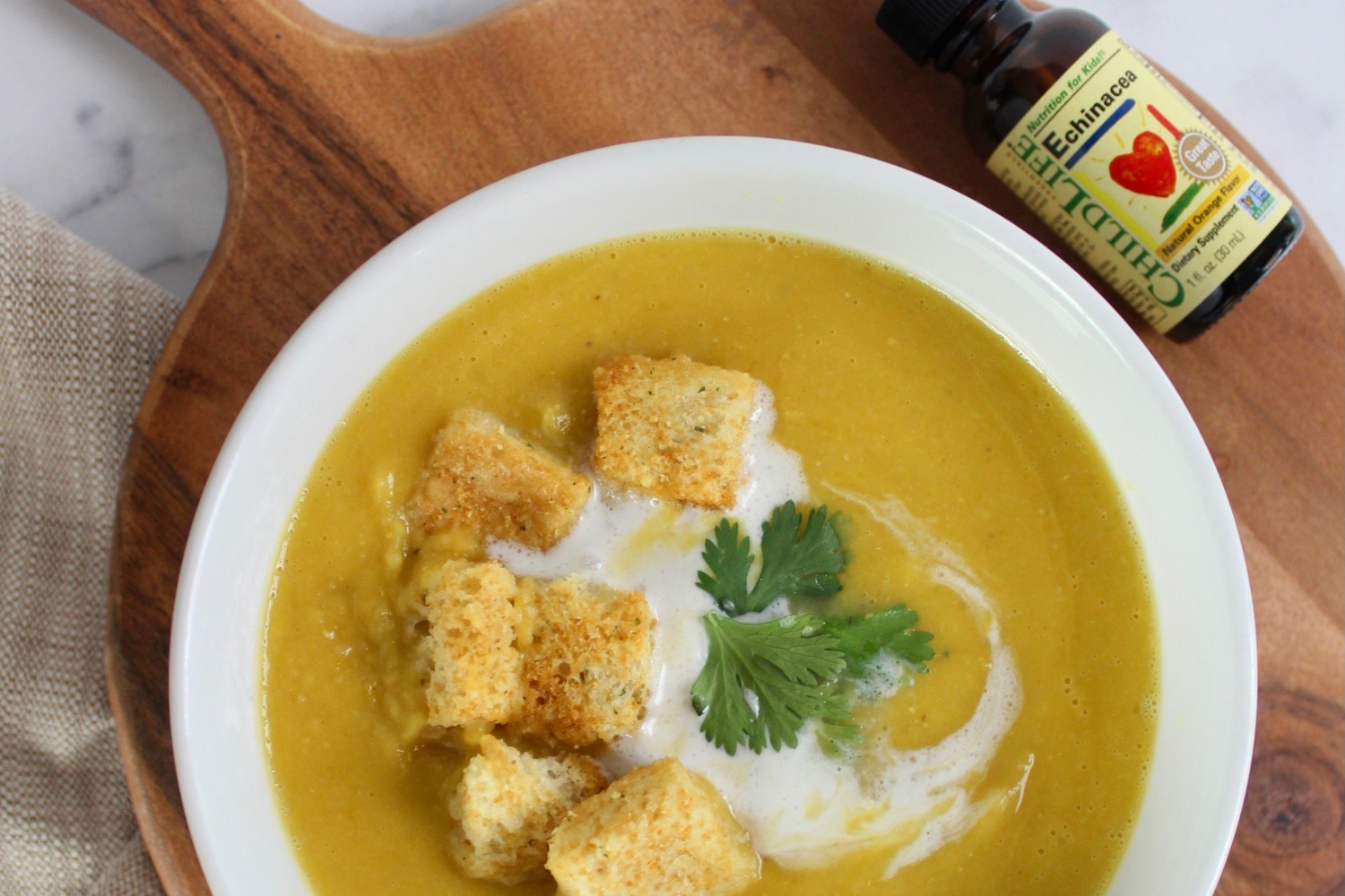 a bowl of butternut squash soup and a bottle of echinacea