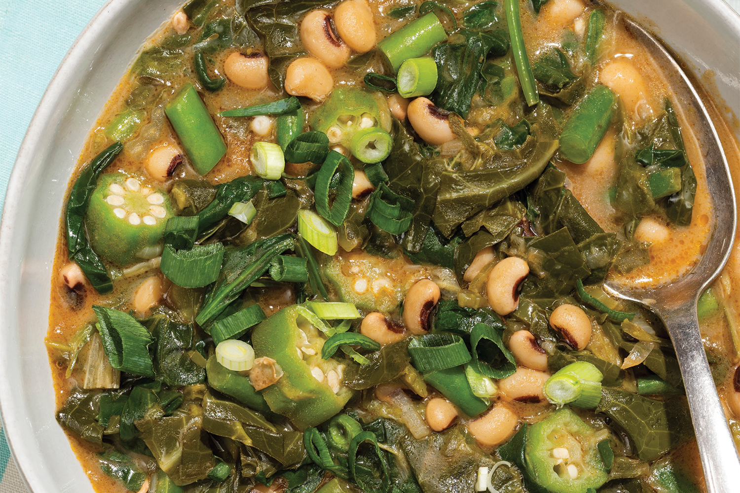 a steaming bowl of spicy gumbo loaded with greens