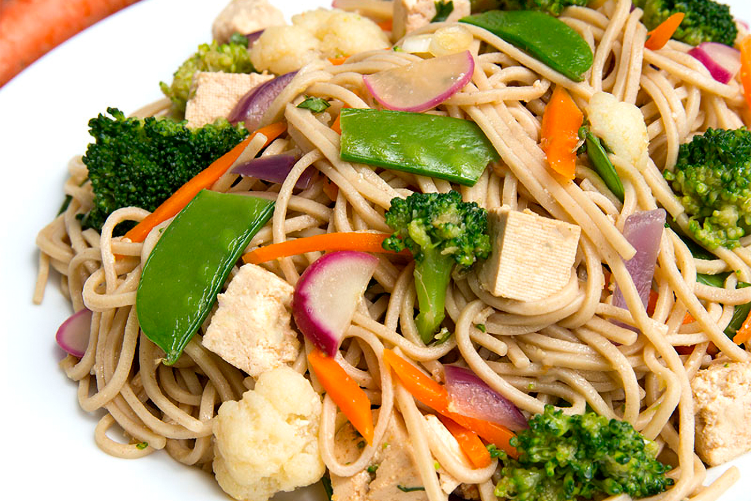 a plate of soba noodles with vegetables and tofu