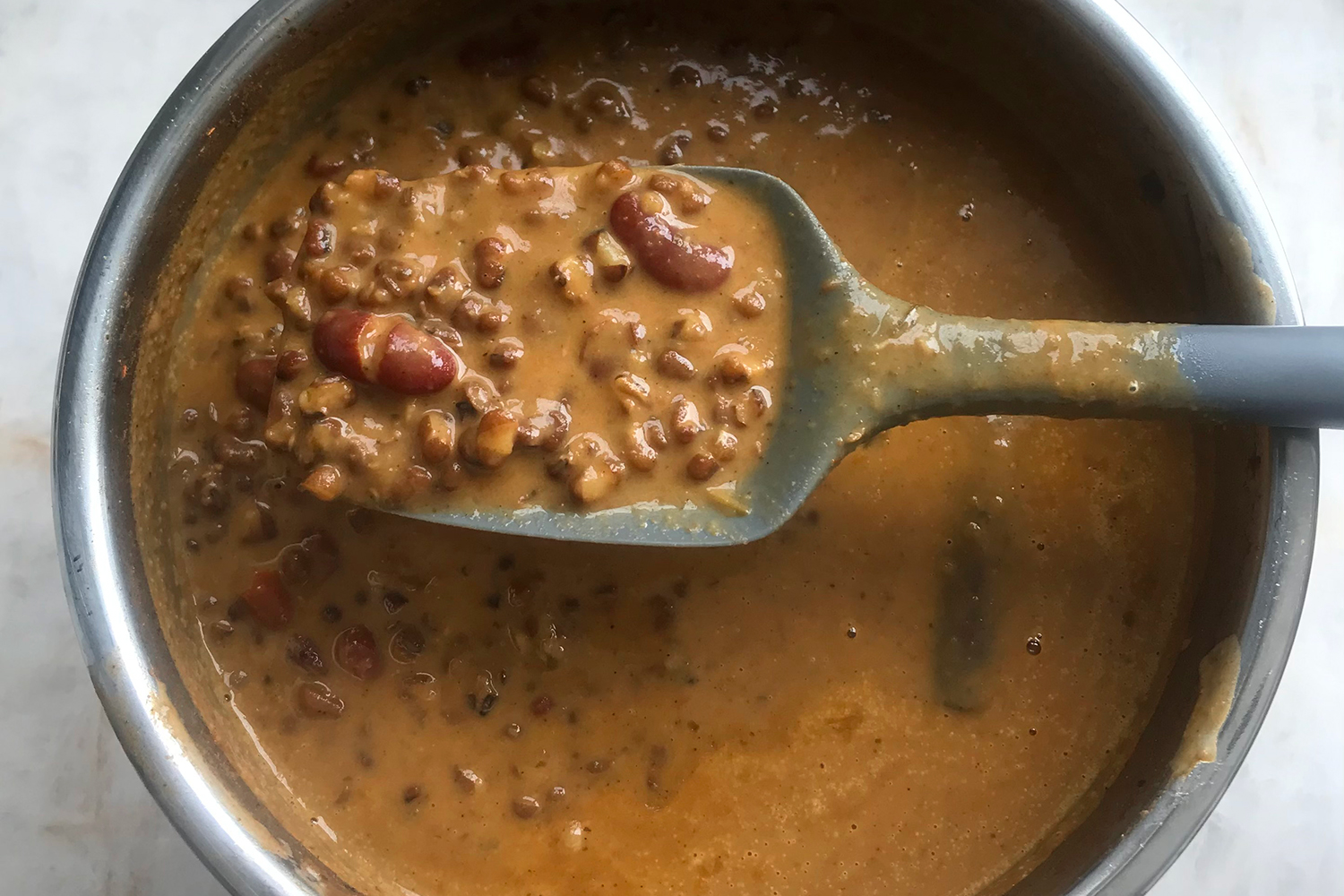 stirring a pot of fresh dal with ghee