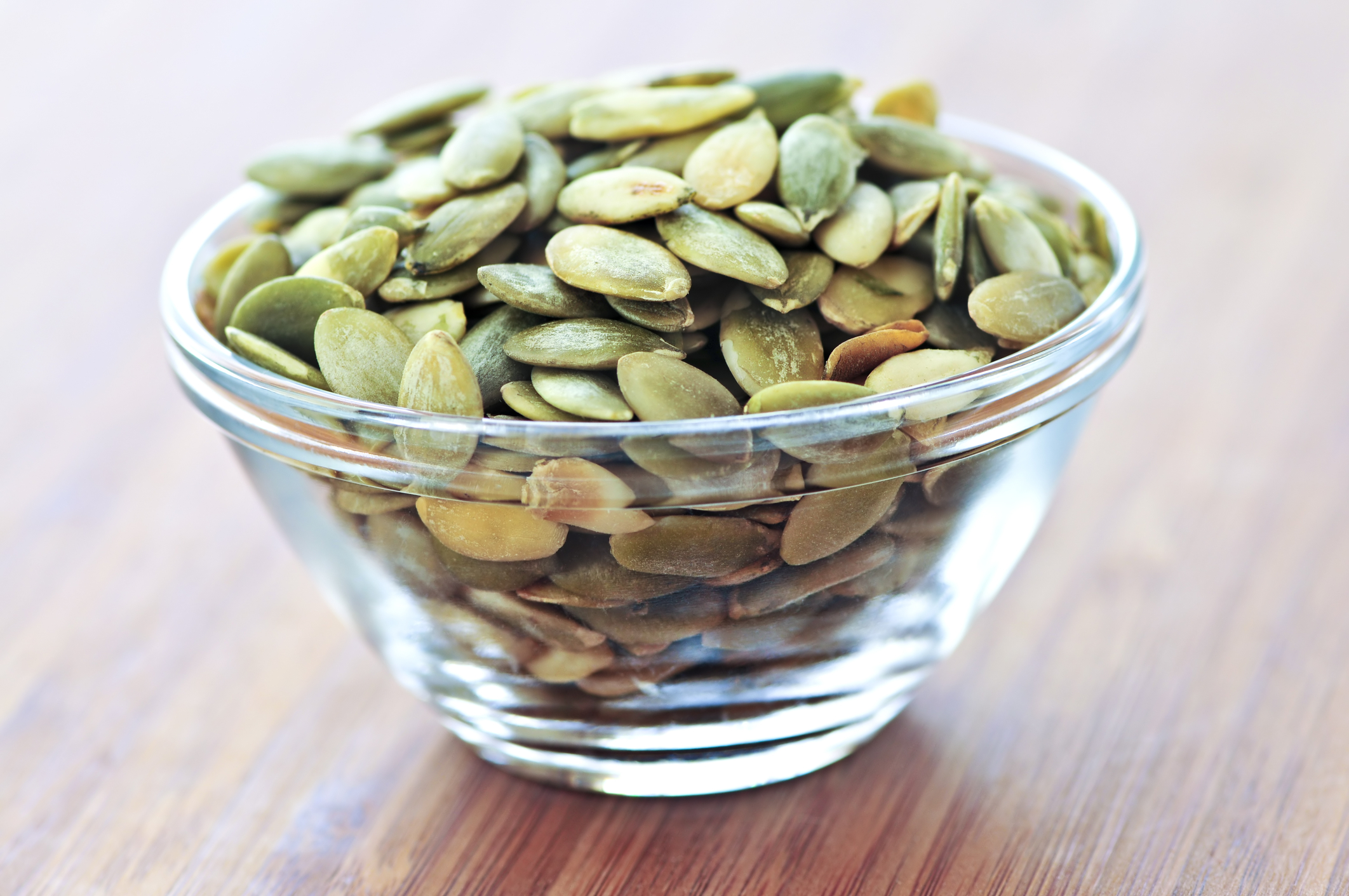 Pumpkin seeds in a glass bowl. 