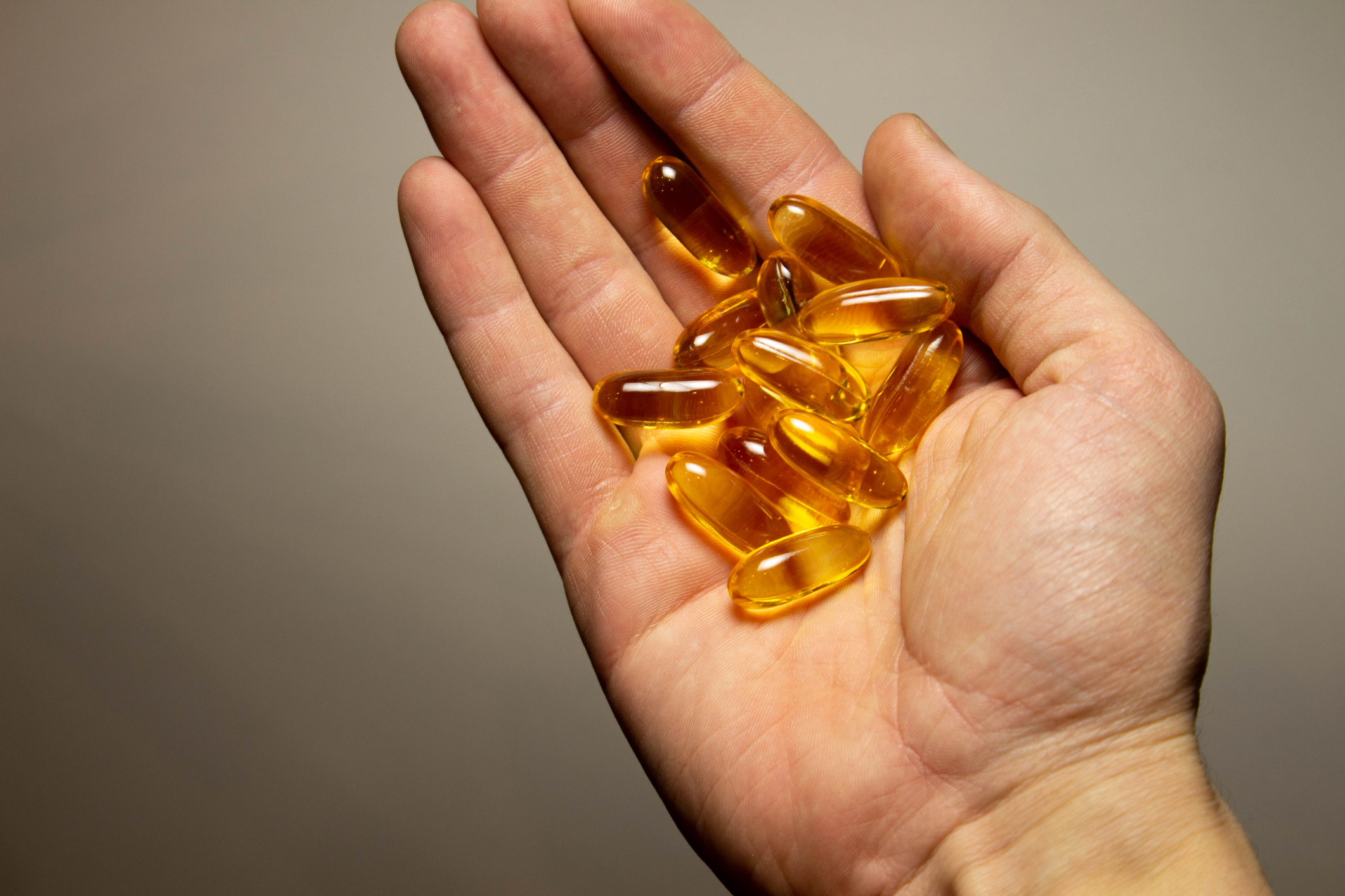 Hand holding omega-3 vitamins. 