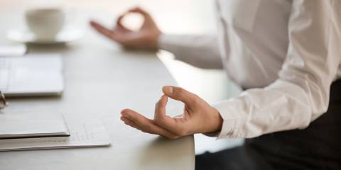 a businesswoman meditating at her desk