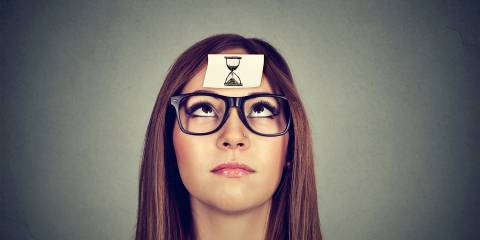 a woman with a picture of an hourglass stuck to her forehead
