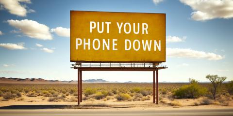 Billboard in the desert that says "Put your phone down."