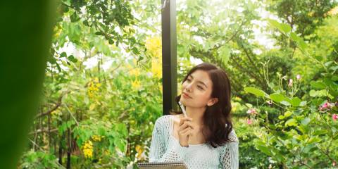 a woman in outside in springtime writing down her goals