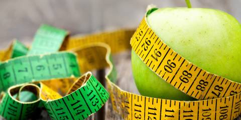 an apple with a measuring tape wrapped around it