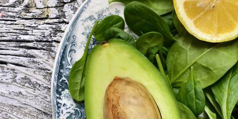 Assortment of spinach, lemon, and avocado on a plate
