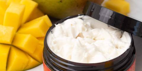 a small jar of lotion and some fresh mangoes