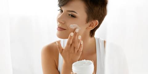 a woman applying skin cream to her face
