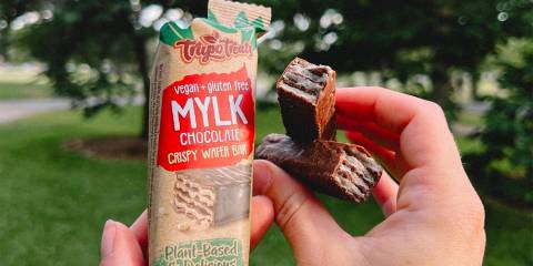 a woman breaking open some crispy chocolate wafer bars