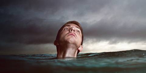 a man up to his neck in a stormy sea