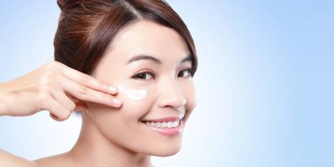 Woman putting cream on her face