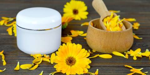 Herbal calendula cream on wooden background.