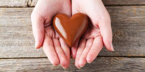 person holds heart chocolate