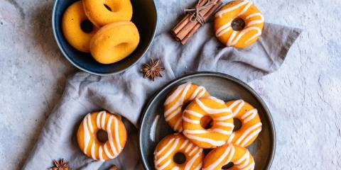 plates of pumpkin donuts decorated differently