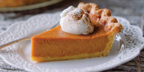 a slice of pumpkin pie with a dollop of whipped cream