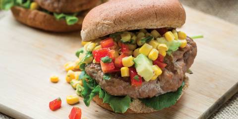 turkey burgers stacked tall with avocado, corn, and peppers