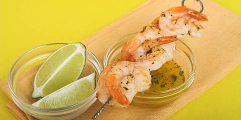 shrimp on the skewer with limes and a butter sauce