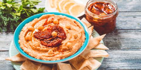 a plate of pita chips and a bowl of hummus