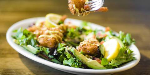 A plate of chicken and greens slathered in honey mustard
