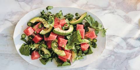 Top view of Spicy Watermelon Salad on a white platter on a white marble background.