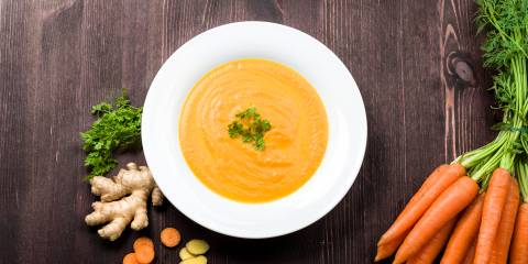 a bowl of carrot and ginger soup with garlic