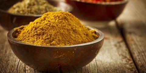 Wooden bowl of ground turmeric