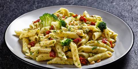 a plate of penne with broccoli and sundried tomatoes
