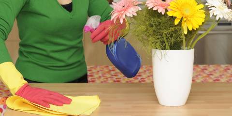 a woman wiping down a table with all-natural cleaning supplies