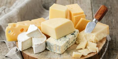 a board of various sliced cheeses