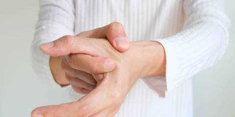 someone massaging an aching thumb joint