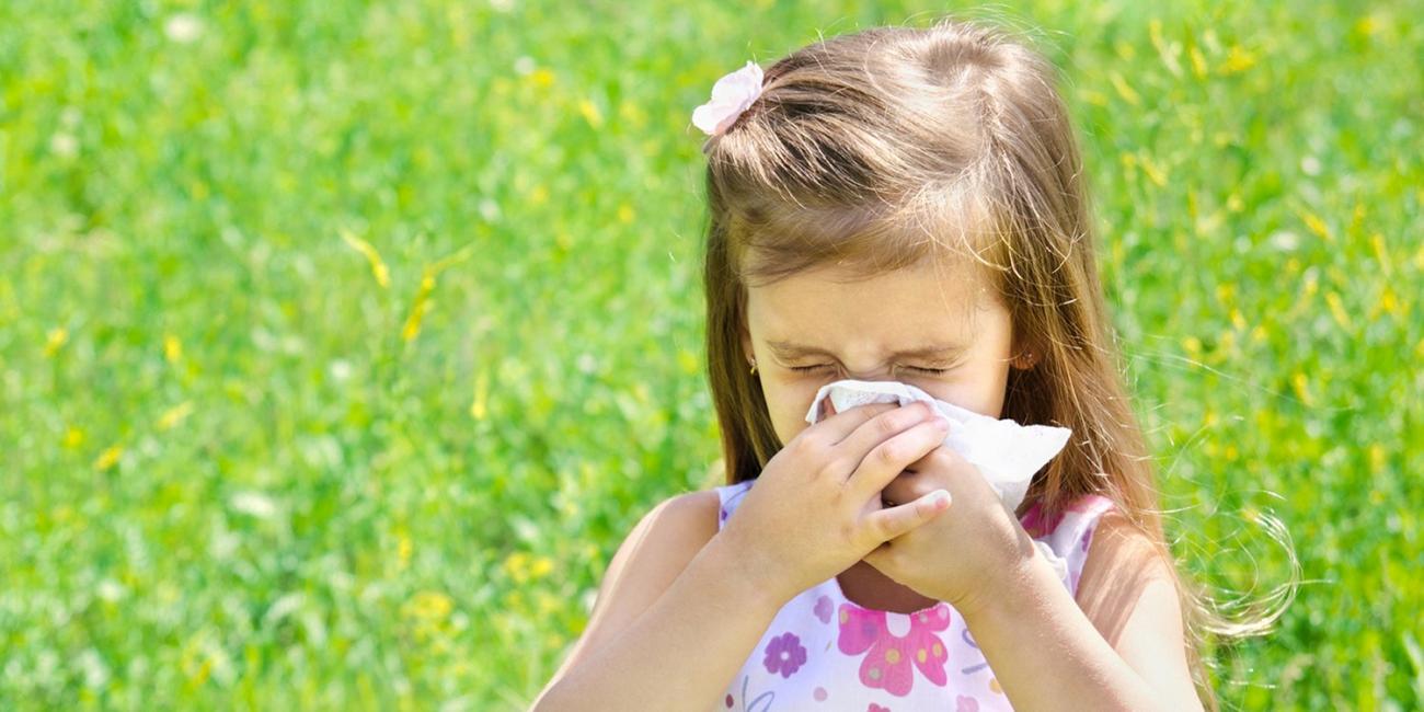 girl sneezing outside